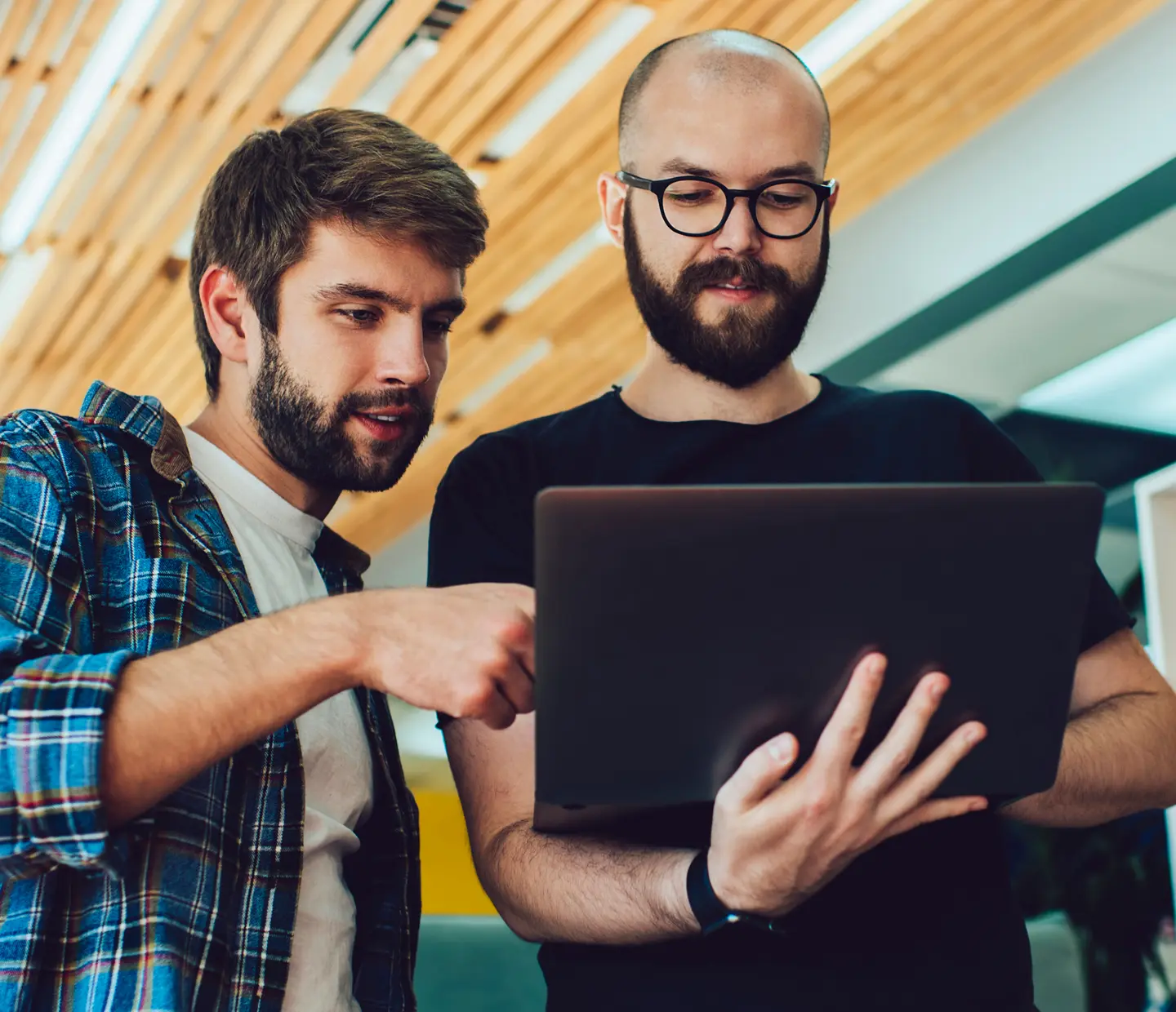 2 men looking at laptop